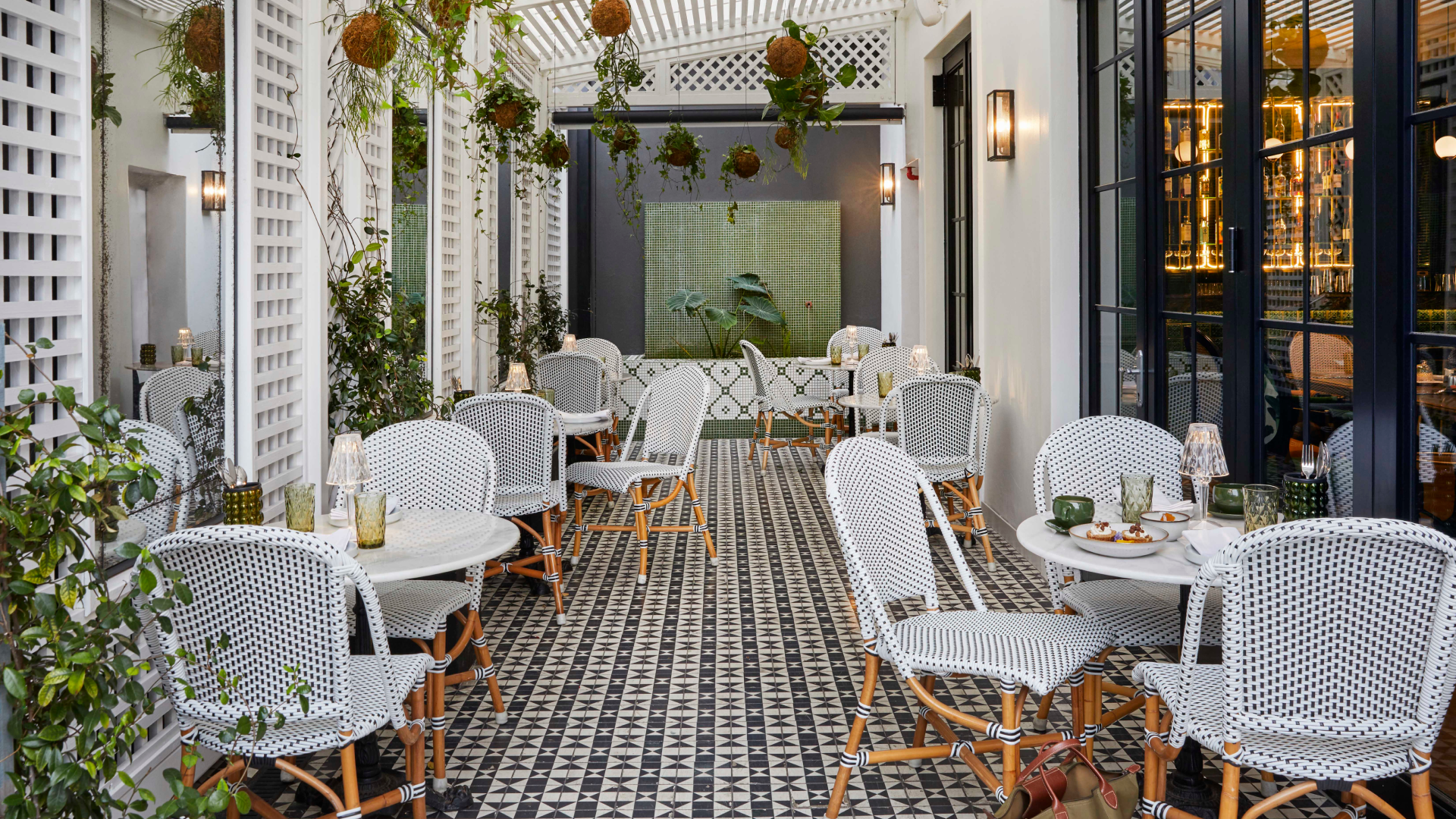 Upper Union Restaurant greenhouse: Outdoor seating area with patterned tile and hanging plants.